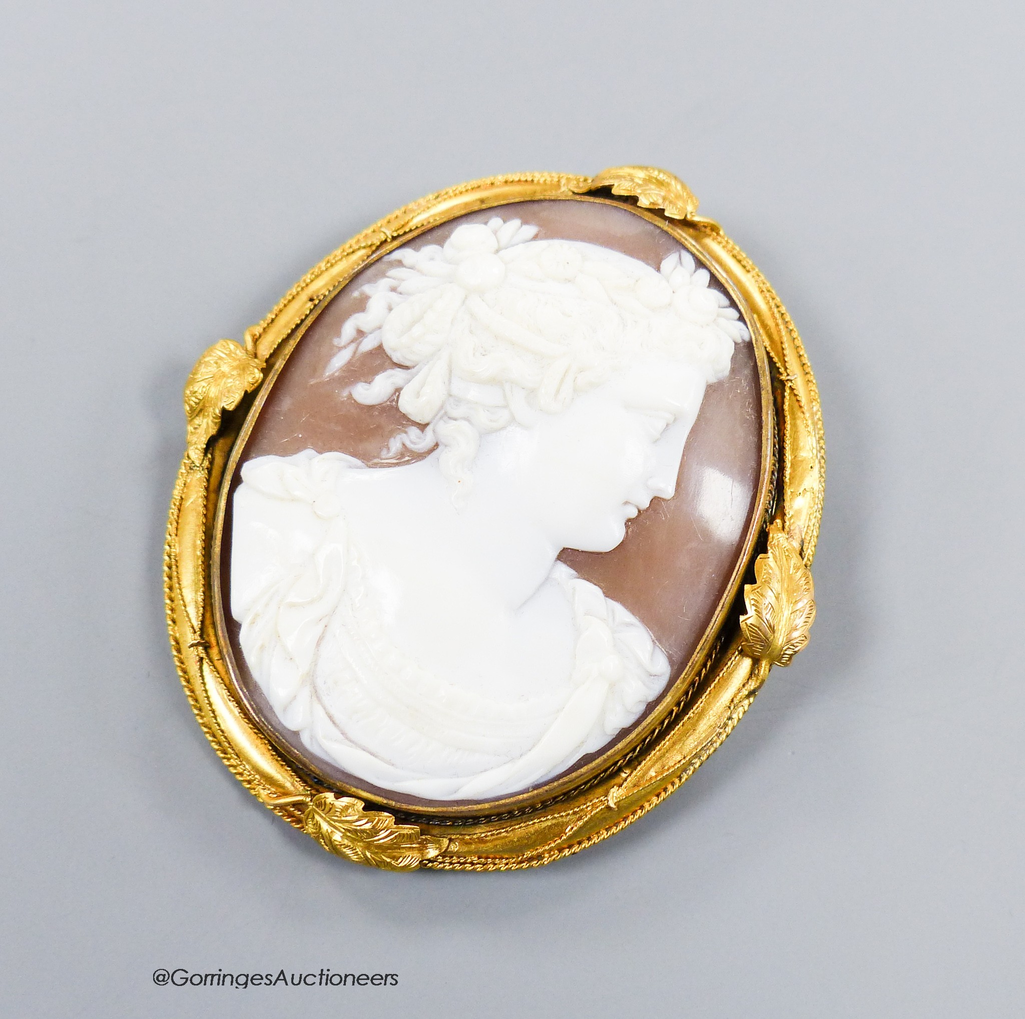 A late Victorian yellow metal mounted oval cameo shell brooch, carved with the bust of a lady to sinister, 6cm, gross weight 22.3 grams.